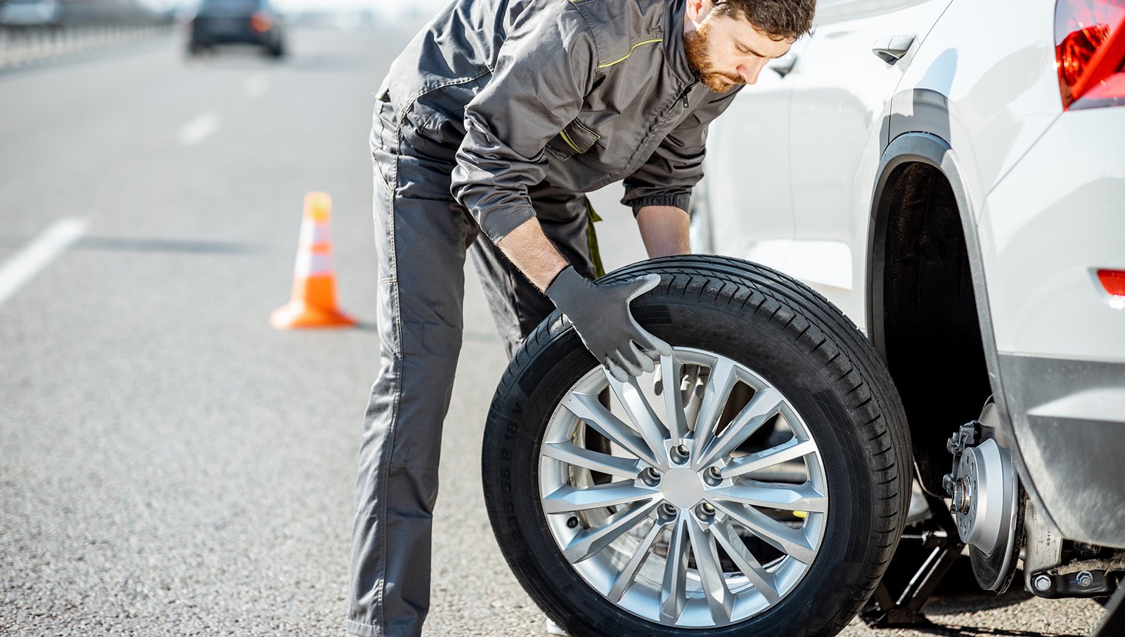 Mobile tire technician performing emergency roadside tire replacement service